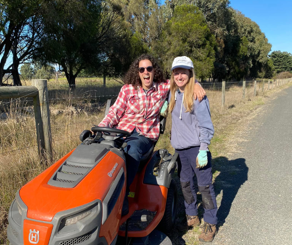 People beside a ride-on lawnmower outside